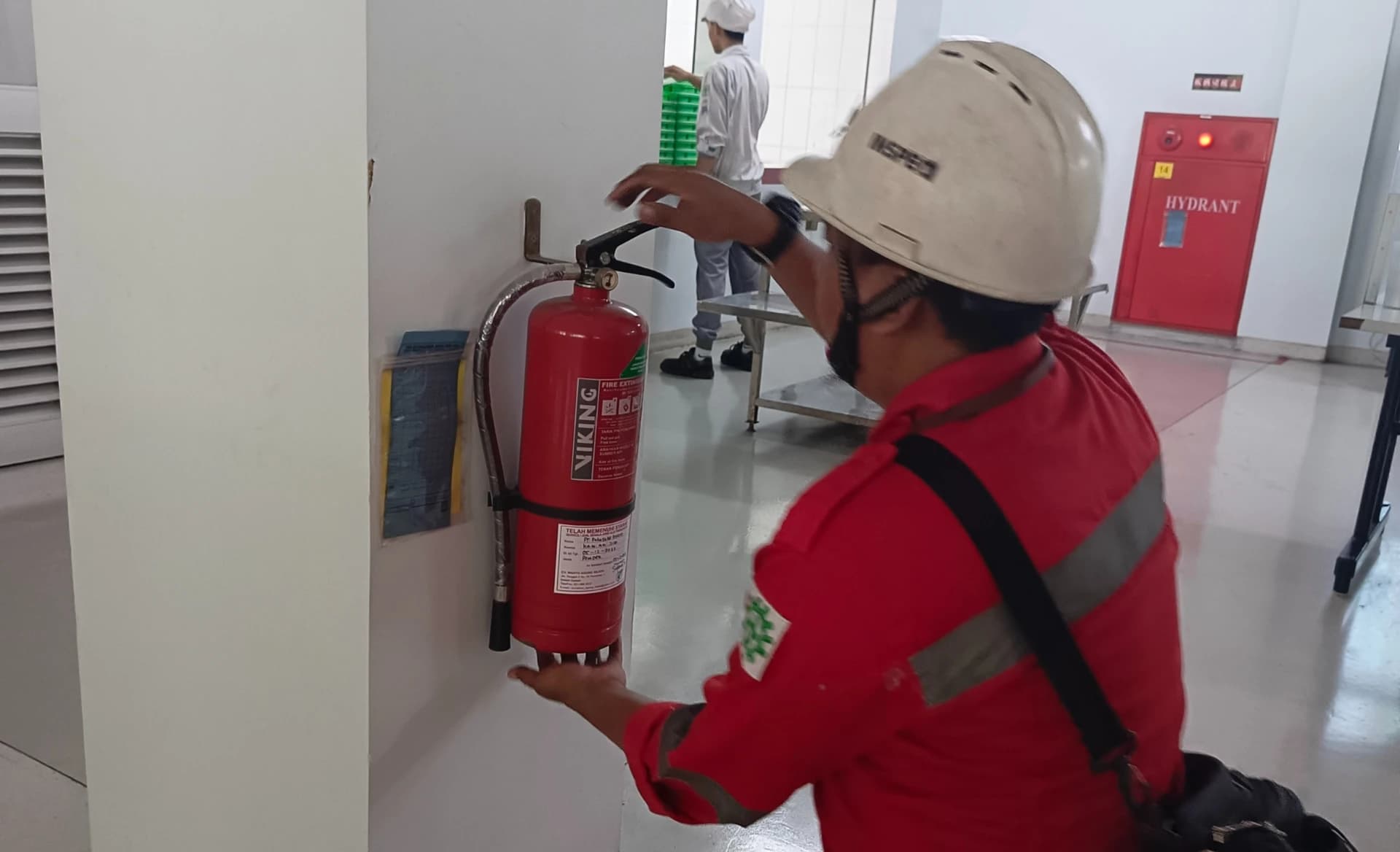 Inspector K3 melakukan inspeksi pencegahan kebakaran di area pabrik.